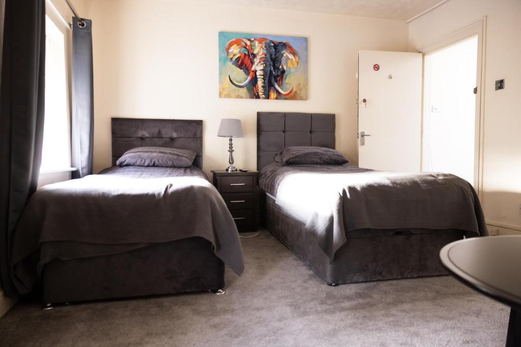 - une chambre avec 2 lits et un tableau mural dans l'établissement COZY PLACE LIVERPOOL, à Liverpool