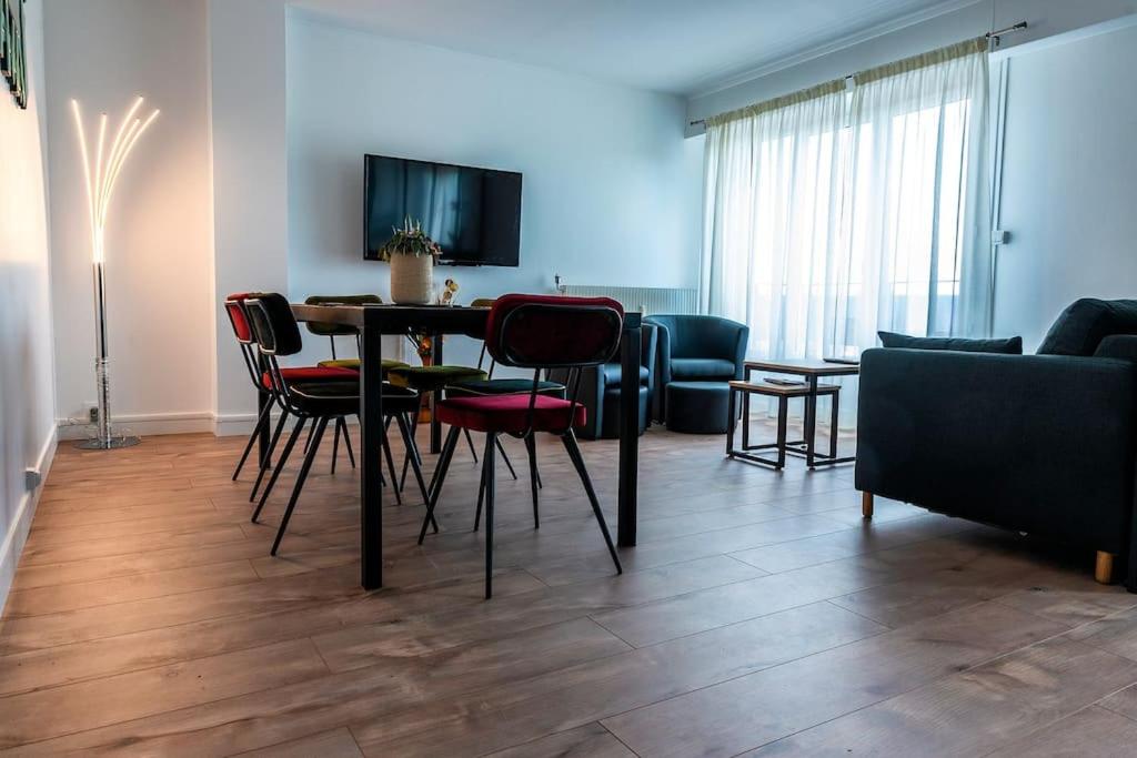 ein Wohnzimmer mit einem Tisch, Stühlen und einem Sofa in der Unterkunft Bel appartement au bord de l'Allier classé 4* in Vichy