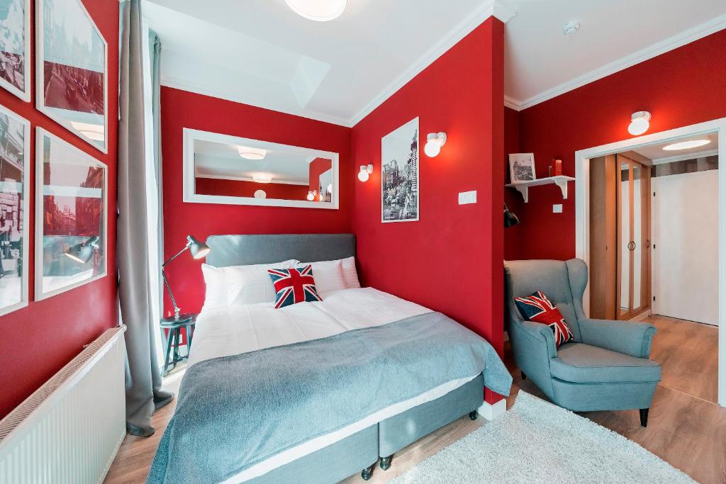 ein rotes Schlafzimmer mit einem Bett und einem Stuhl in der Unterkunft Revelton Studios Františkovy Lázně in Franzensbad