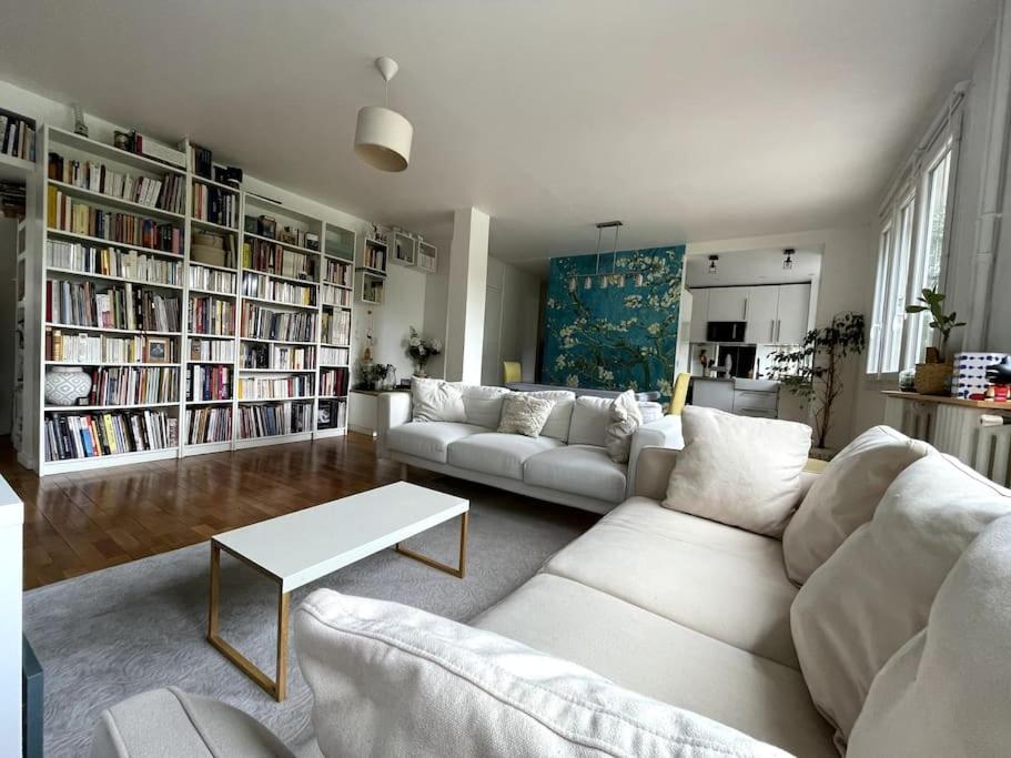 una sala de estar con muebles blancos y estanterías en Grand Appartement proche Paris, en Sèvres