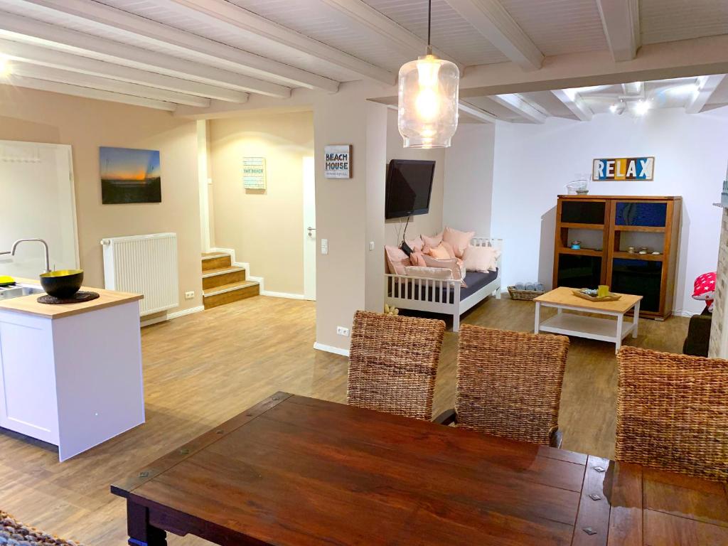 sala de estar con mesa de madera y sillas en Ferienwohnungen Arp "Beach House" mit Terrasse und Parkplatz, en Itzehoe