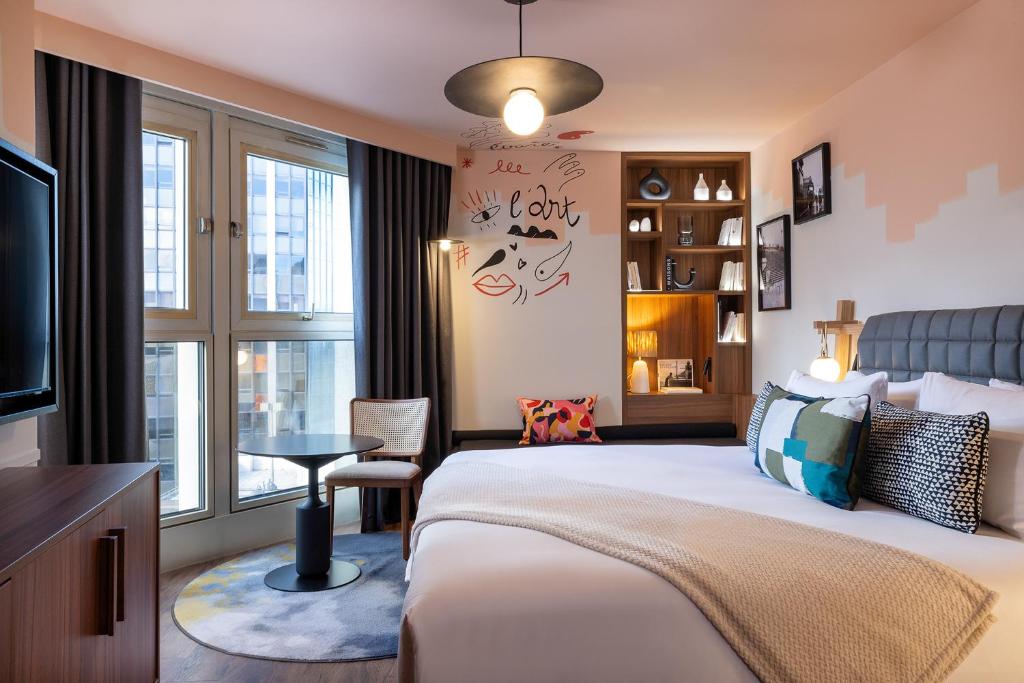 a hotel room with a bed and a window at Les Artistes in Paris