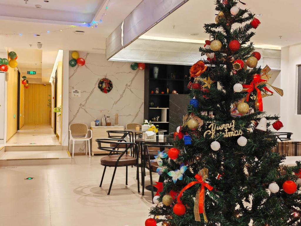 a christmas tree in a room with a table at Suzhou MeetU Intl Youth Hostel in Suzhou