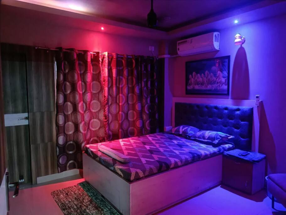 fioletowy pokój z łóżkiem i oknem w obiekcie Your Right Place w mieście Guwahati