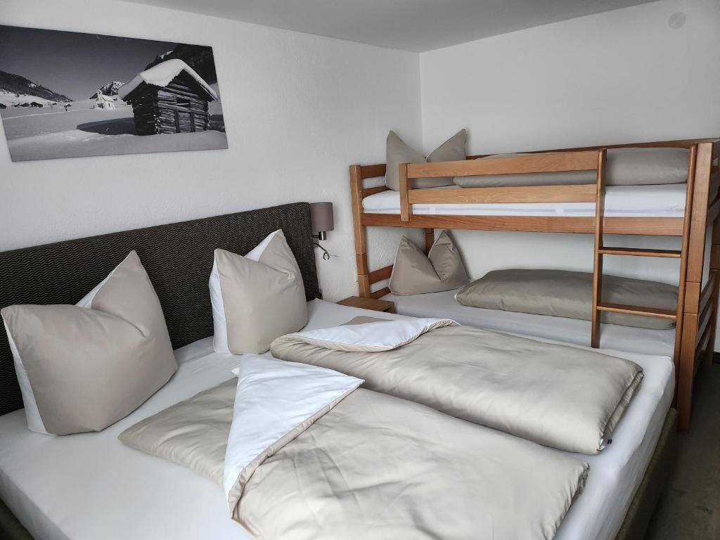 two beds in a room with a bunk bed at Bauernhof Waldegger in Nauders