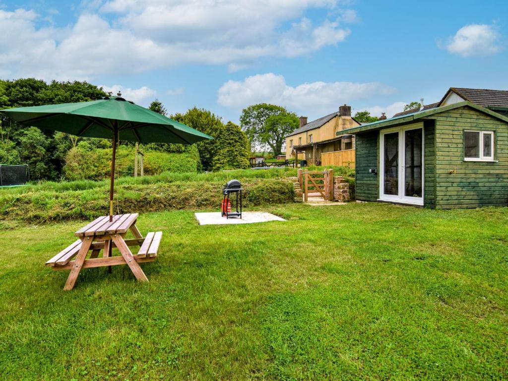 a picnic table and an umbrella in a yard at 1 Bed in Barnstaple 40352 in Chapelton