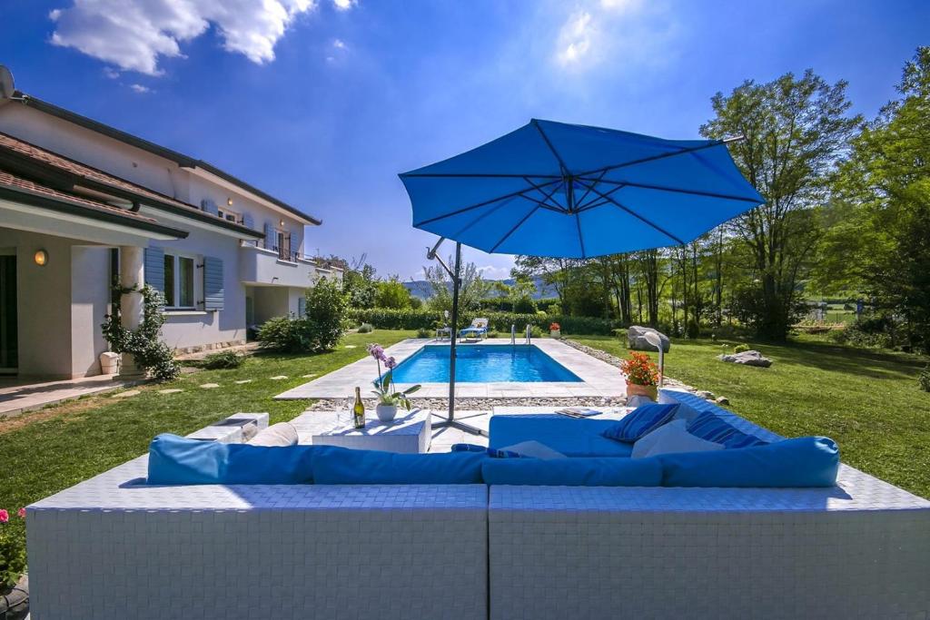 a blue umbrella sitting on a table next to a pool at Villa Rupena in Buzet