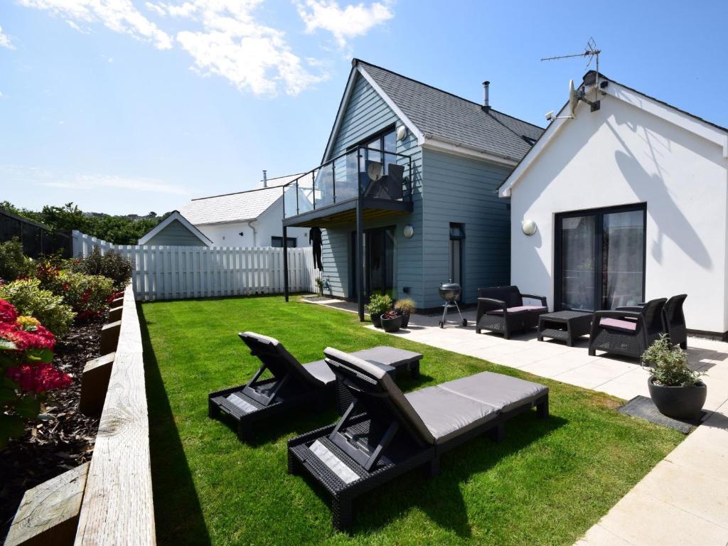 un patio con sillas negras y una casa en 3 Bed in Westward Ho 46252 en Northam
