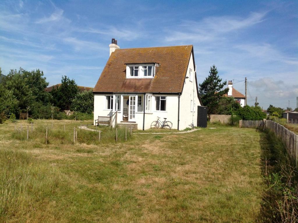 una casa blanca con techo marrón en un campo en 3 Bed in Dymchurch 46913, en Littlestone-on-Sea