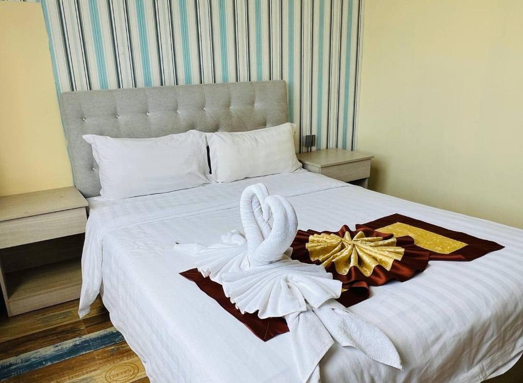 Una cama con dos cisnes encima. en Fusion Hotel, en Sihanoukville
