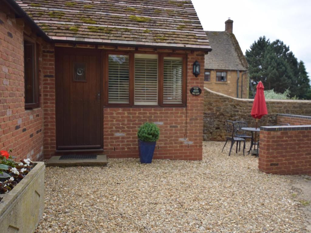 a brick shed with a table and a patio at 1 bed property in Banbury Cotswolds CC012 in Shotteswell