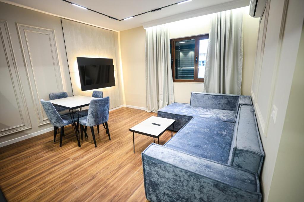 een kamer met een bank, een tafel en een tv bij Miku Apartment-Extraordinary 1BD At Komuna e Parisit in Tirana