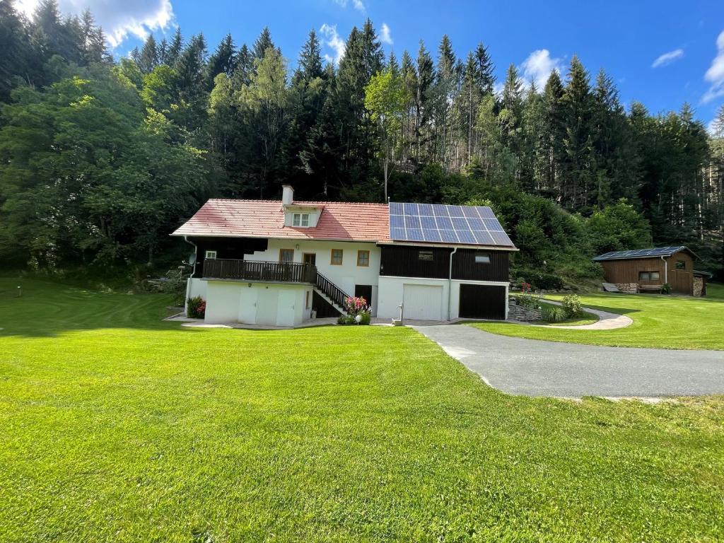 een huis met een zonnedak en een tuin bij Ferienhaus Holzer in Mönichwald