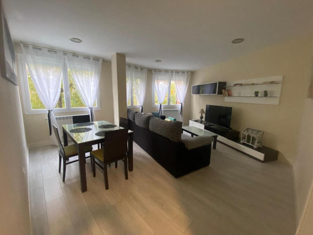 a living room with a couch and a table and chairs at La casa de las Flores in Ponferrada