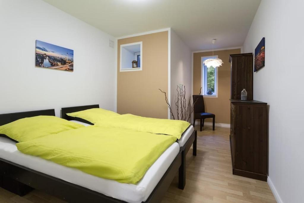 1 dormitorio con 1 cama con sábanas amarillas en Cityapartment Pankow en Berlín