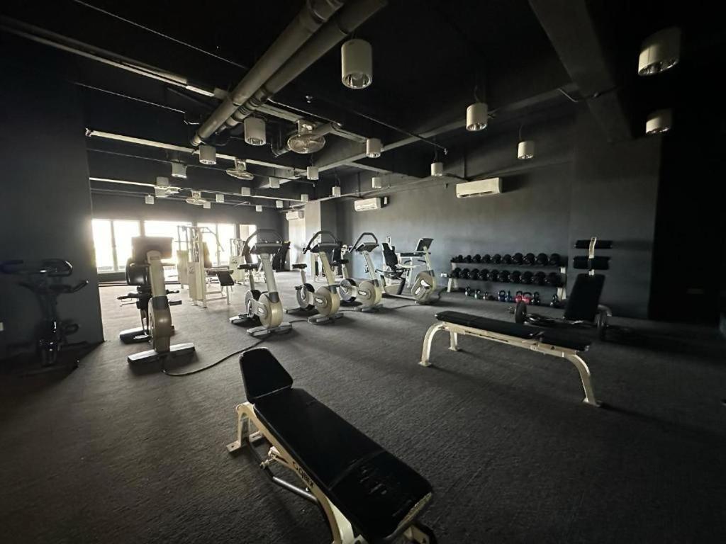 une salle de sport avec plusieurs tapis de course et machines dans l'établissement SW Rental, à Penampang