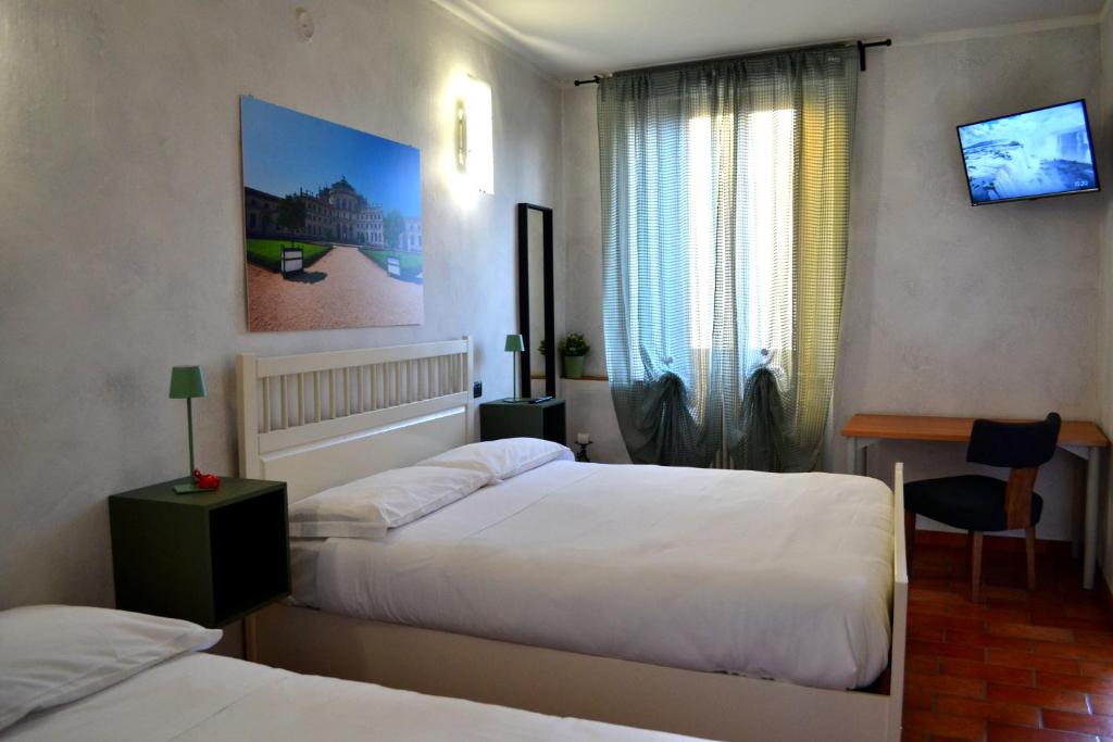 a hotel room with two beds and a window at DOMUS Hotel in Caselle Torinese