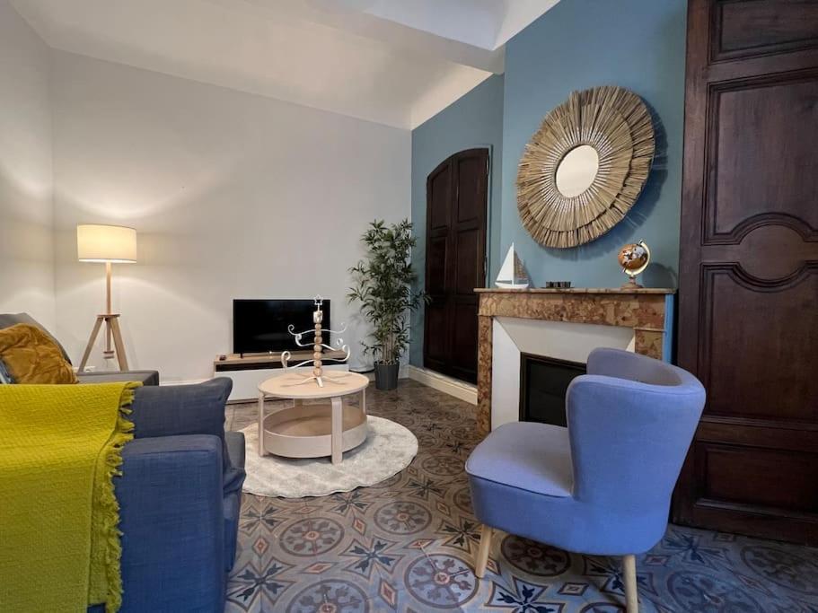 uma sala de estar com uma cadeira azul e uma lareira em Appartement spacieux et calme à Aix en Provence em Aix-en-Provence