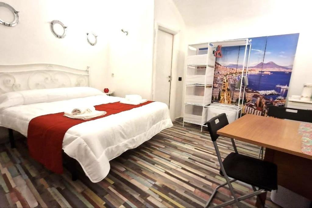 a hotel room with a bed and a desk and a table at [Sea Front] - Welcoming Room in Mergellina in Naples