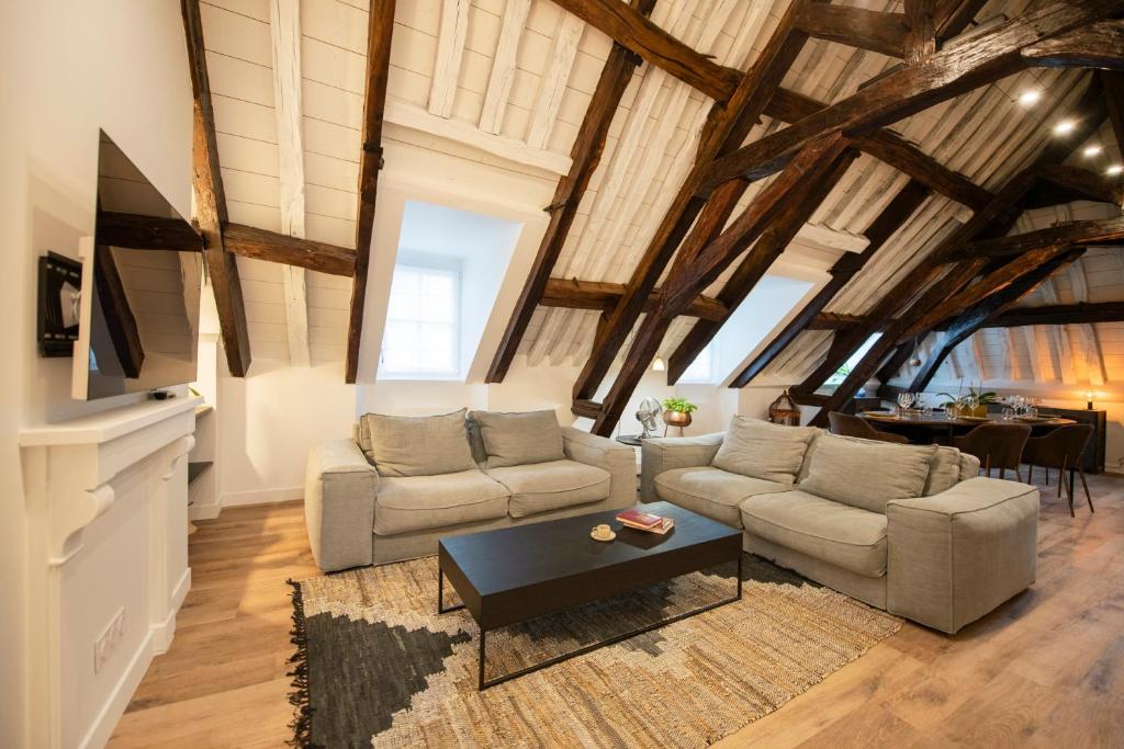 a living room with two couches and a table at Le Laurencin Sens - Le Family - Cœur de ville in Sens