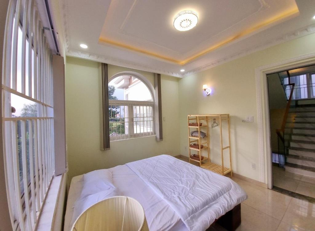 a bedroom with a bed and a window at Bếp Ông Tỏi Homestay in Ho Chi Minh City