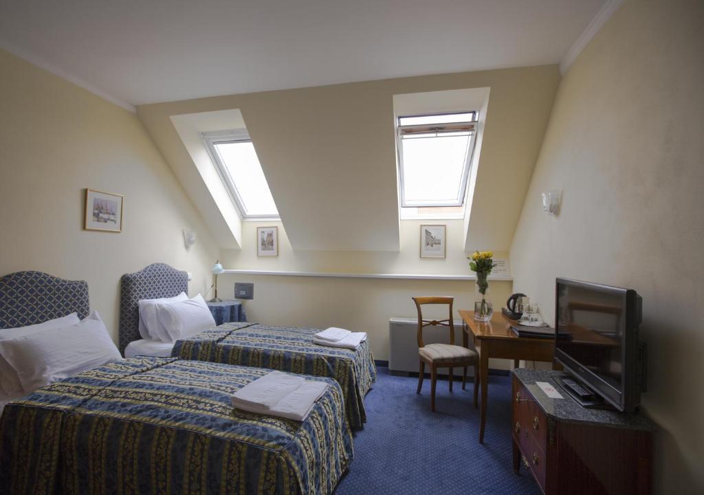 ein Hotelzimmer mit 2 Betten und einem TV in der Unterkunft Hotel Tyl in Prag