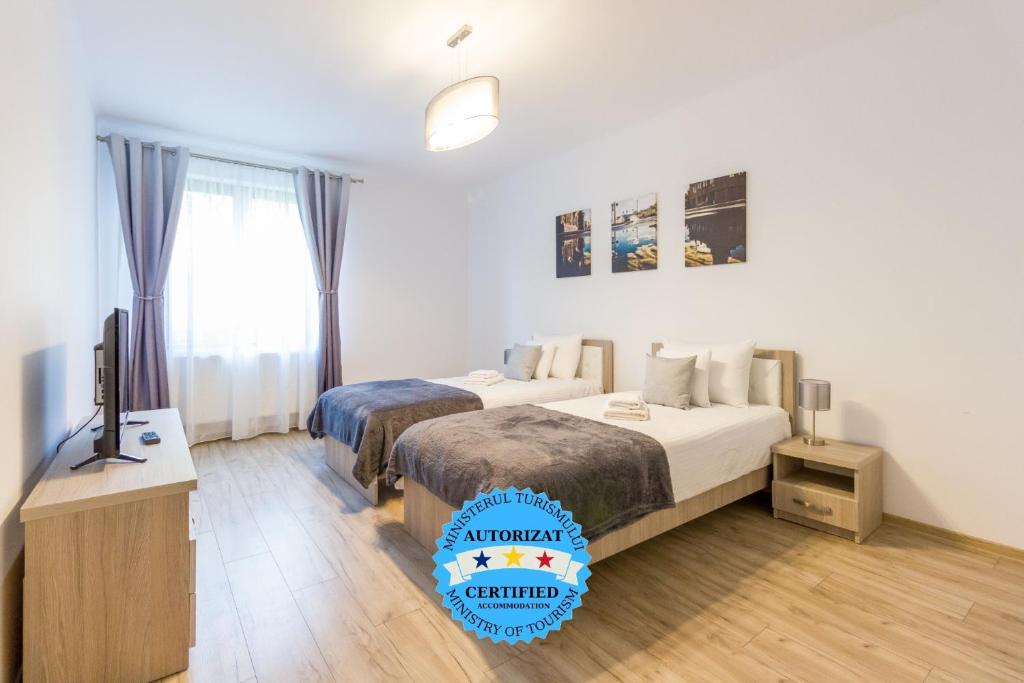 a hotel room with two beds and a television at Spacious and Quiet 2 Bedroom Apartment in Cluj-Napoca