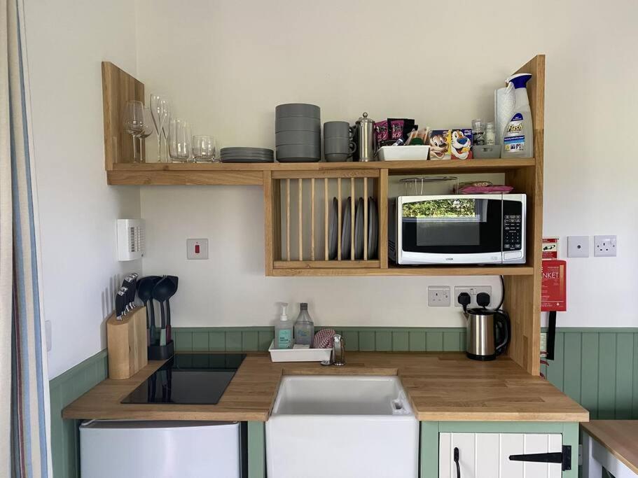 a kitchen with a counter top with a microwave at The Lily Pod in New Abbey