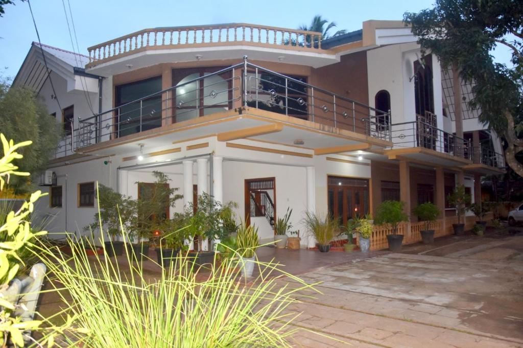 Cette grande maison blanche dispose d'un balcon. dans l'établissement Yellow Birds Resort, à Anurâdhapura