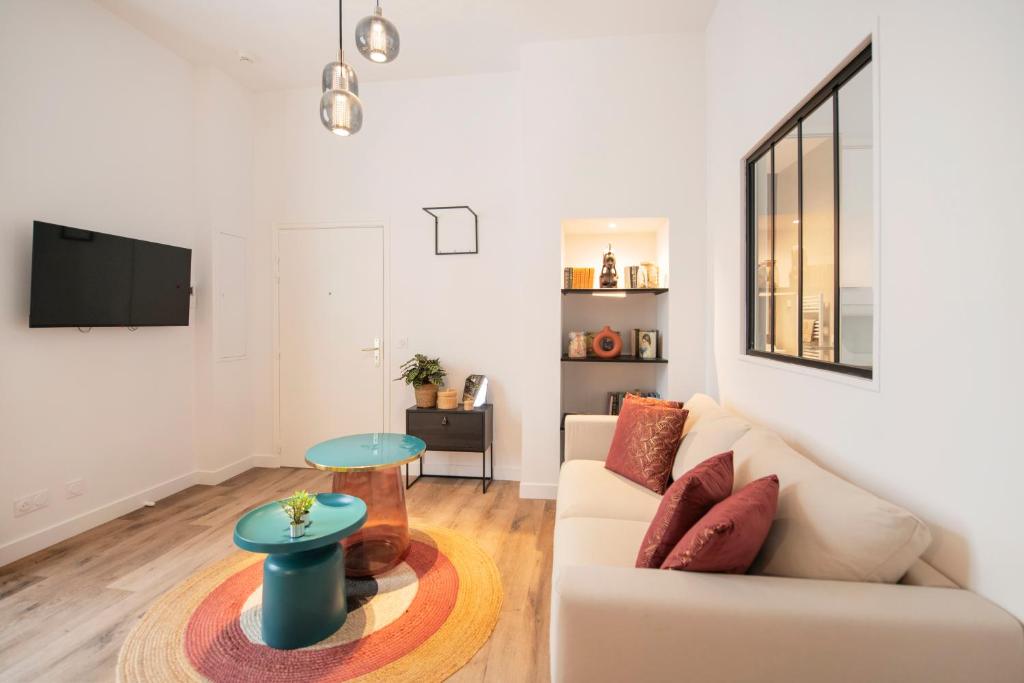 a living room with a couch and a table at Le Laurencin Sens - La Verrière in Sens