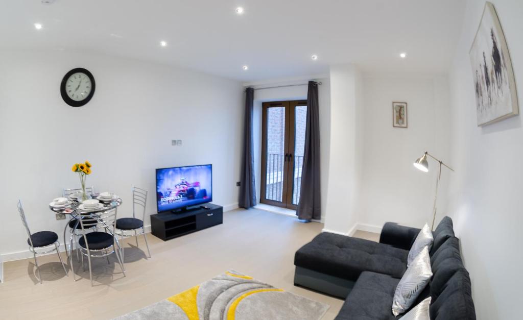 a living room with a couch and a tv at Beautiful 1 Bed Apartment in Centre of St Albans - Free Parking - 5 min walk to St Albans city centre & Railway station, 15mins drive to Harry Potter World - Free Super-fast Wifi in St. Albans