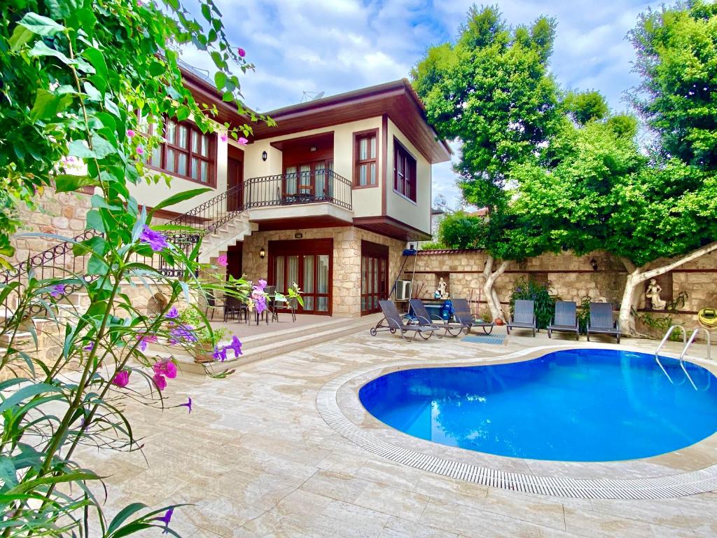 a house with a swimming pool in front of a house at Attalos Villa in Antalya