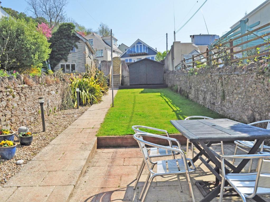 een patio met een tafel en stoelen en een tuin bij 3 Bed in Brixham BX001 in Brixham