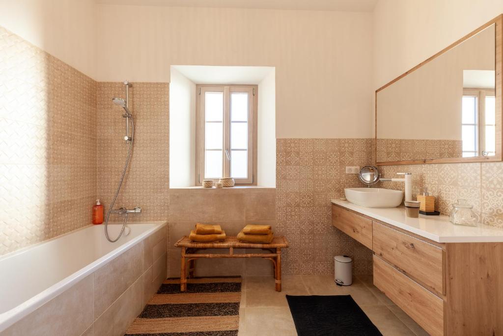 a bathroom with a tub and a sink and a mirror at La Petite Bastide in Sanary-sur-Mer