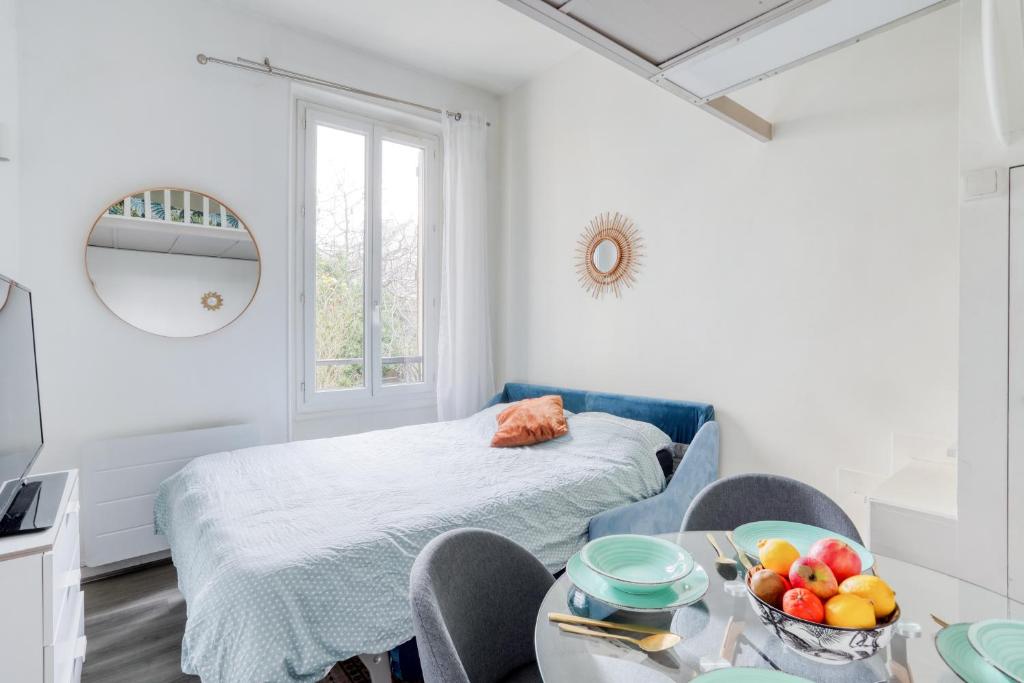 a room with a bed and a table with a bowl of fruit at Chic Appartement Climatisé à 10 Minutes de Paris: Confort et Élégance in Maisons-Alfort