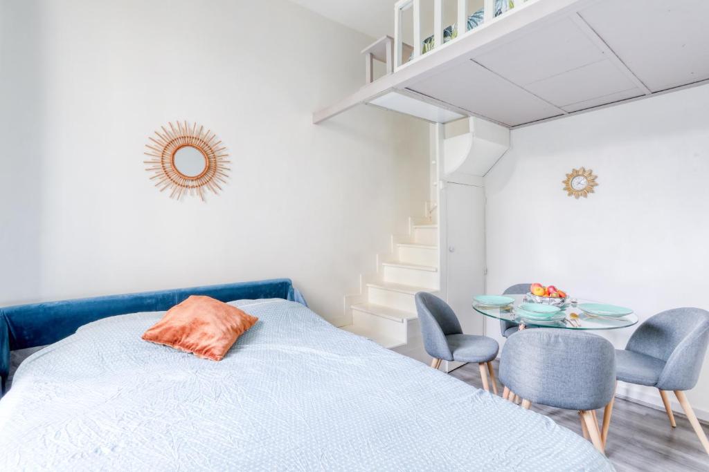 a bedroom with a bed and chairs and a table at Chic Appartement Climatisé à 10 Minutes de Paris: Confort et Élégance in Maisons-Alfort