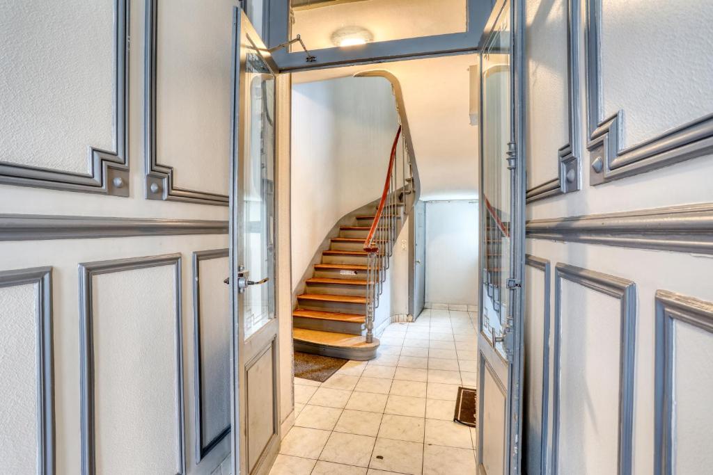 a hallway with a staircase in a house at Chic Appartement Climatisé à 10 Minutes de Paris: Confort et Élégance in Maisons-Alfort