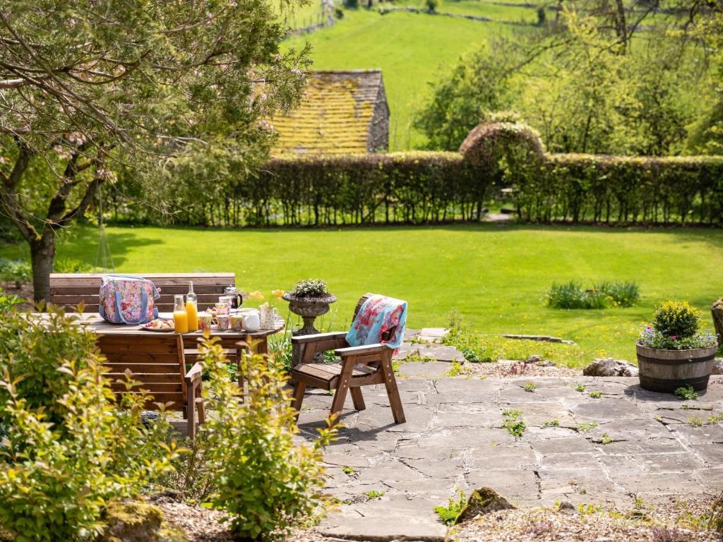 a wooden table and chairs in a garden at 4 bed in Priestcliffe 57687 in Millers Dale