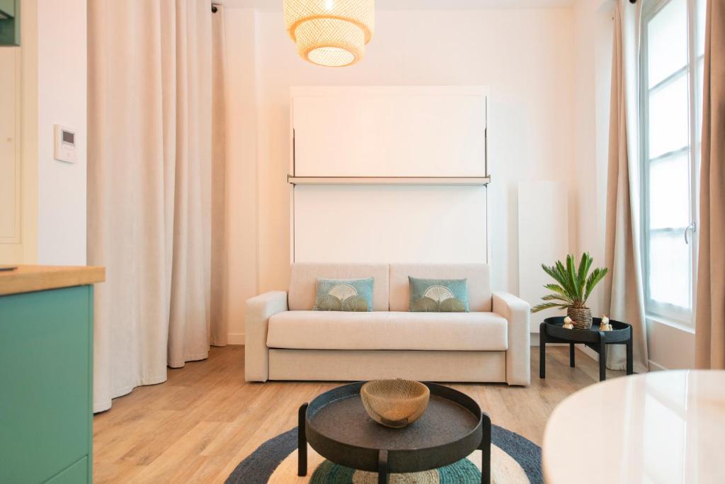 een woonkamer met een bank en een tafel bij Le Laurencin Sens - Le Zen in Sens