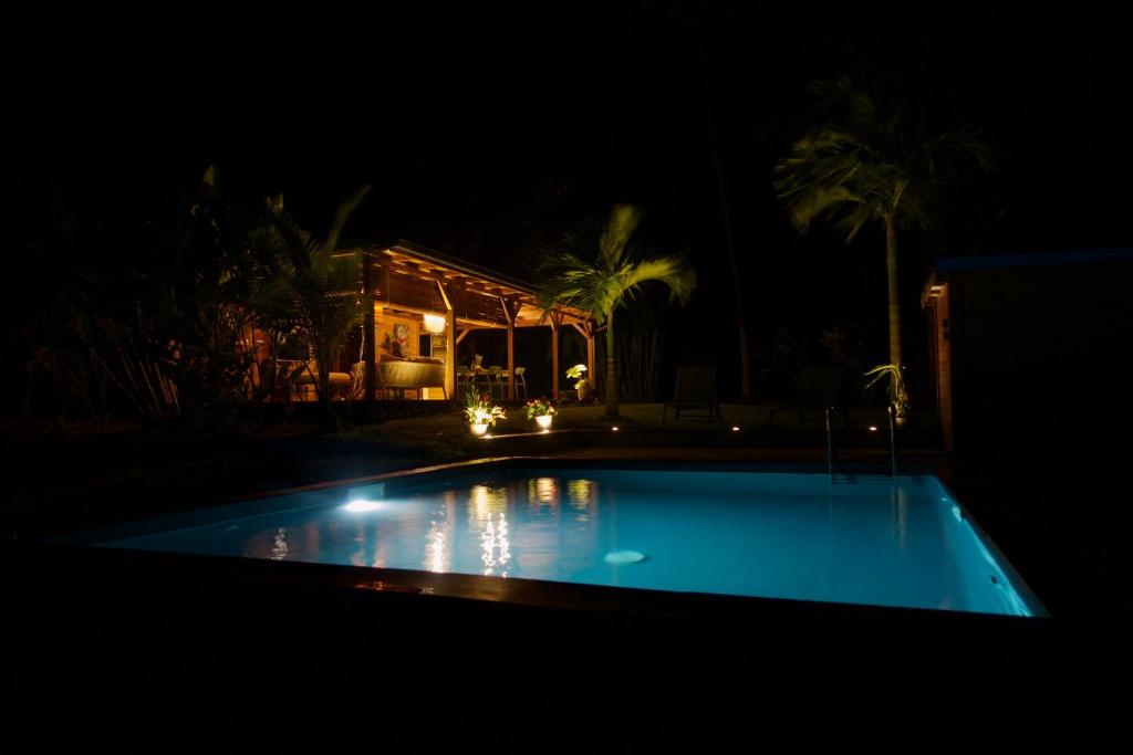 a swimming pool at night with a house at Kaya Lodge in Basse-Pointe