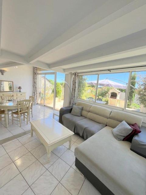 un salon avec un canapé et une table dans l'établissement Agréable maison avec terrasse et piscine collective -6PQ32, au Barcarès