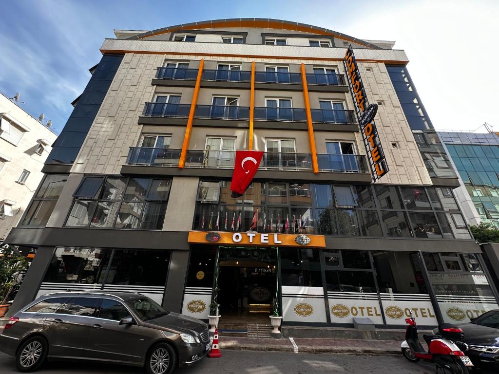um edifício com um carro estacionado em frente em Comfort Başaran OTEL em Antalya