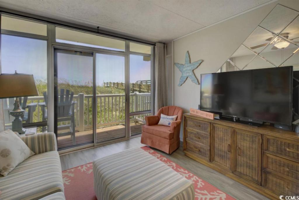 een woonkamer met een grote flatscreen-tv bij Seaside Elegance Your Coastal Getaway in Myrtle Beach