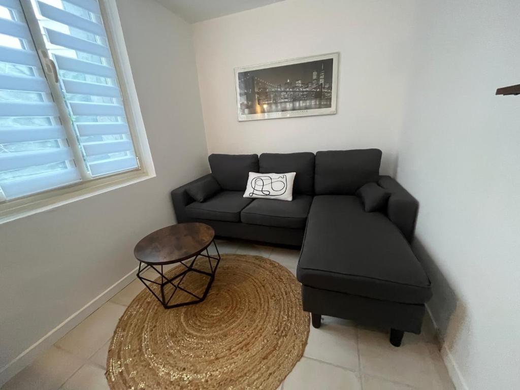 a living room with a couch and a table at Le Duo de la Foret - Logement F1 in Sahurs