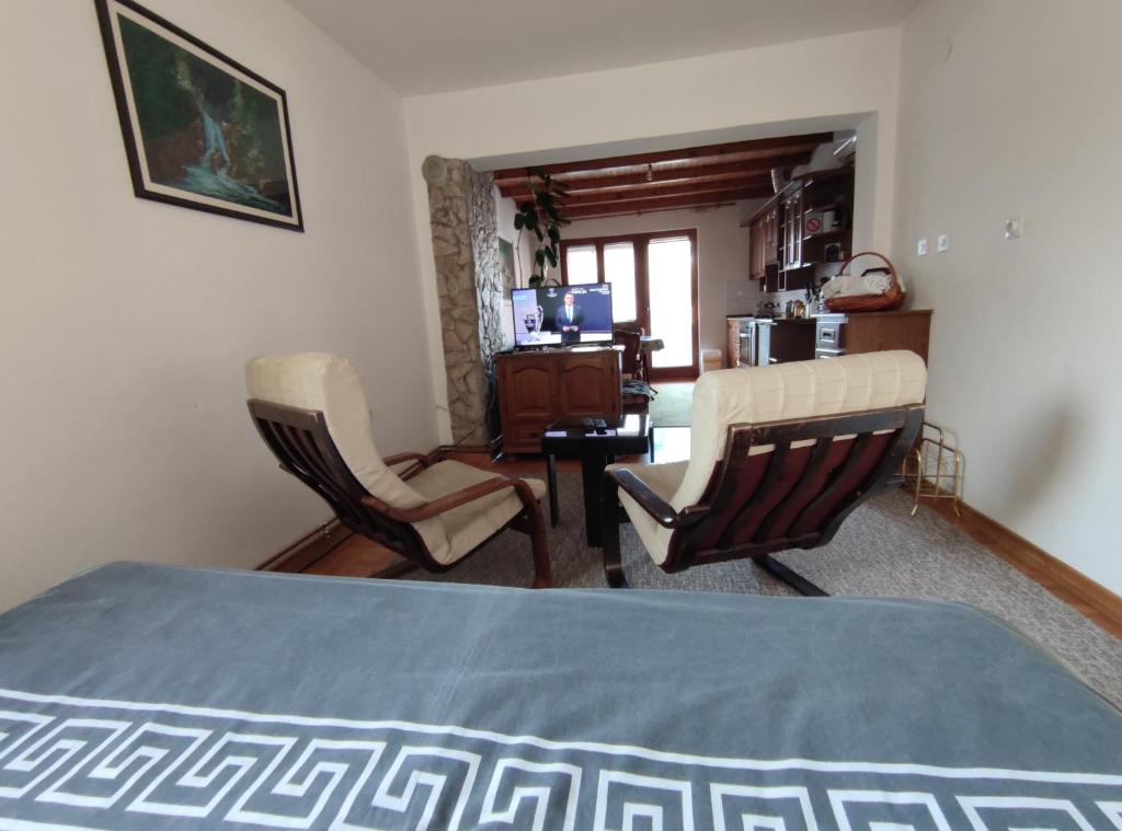 una camera con un letto e due sedie e una scrivania di Nikolic Apartment a Leskovac