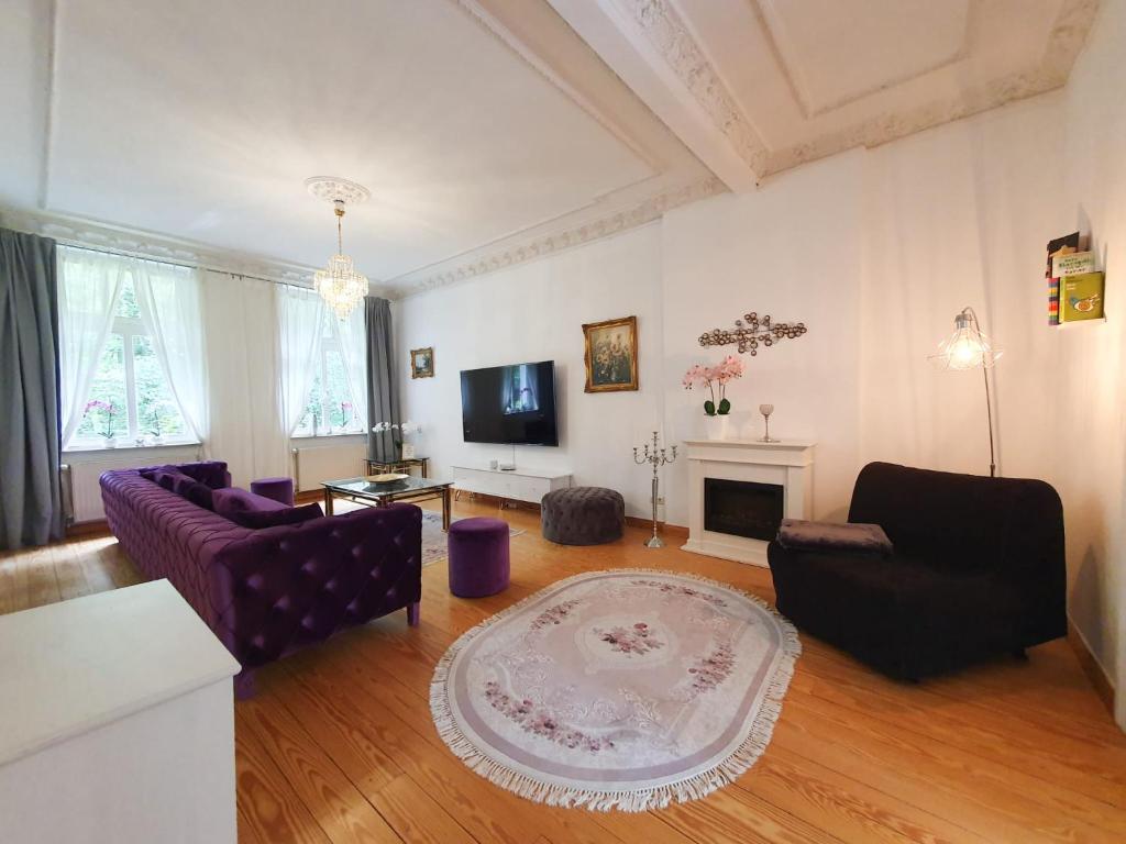 ein Wohnzimmer mit 2 Sofas und einem TV in der Unterkunft DEUTSCHE OSTSEEVILLA - große Villa mit Sauna, Spielplatz, PKW-Stellplätze, großer Garten in Rostock