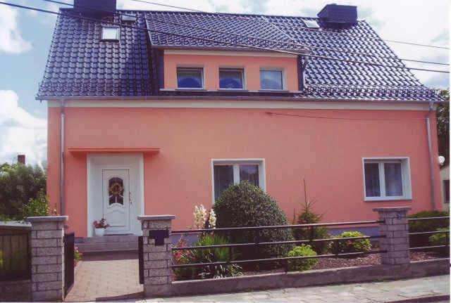 a pink house with a fence in front of it at Ferienwohnung DZ Blesse Allstedt in Allstedt