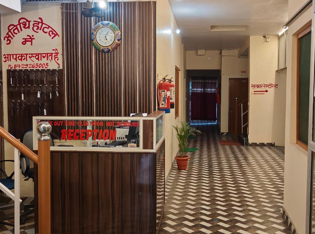 a hotel lobby with a clock on the wall and a corridor at Atithi Hotel in Paliā Kalān