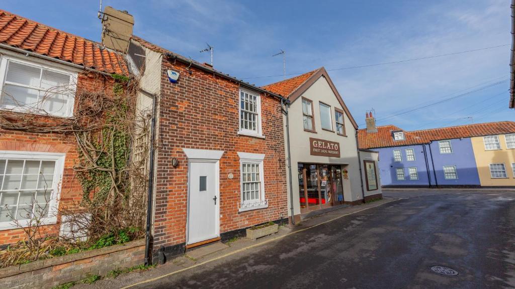 an empty street in a small town with buildings at Angel Cottage in Southwold