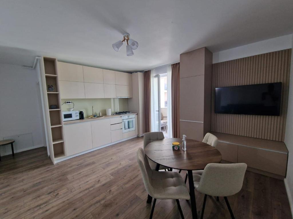 un soggiorno con tavolo e sedie e una cucina di Blue apartment nearby Amethyst & Vivo Mall a Floreşti